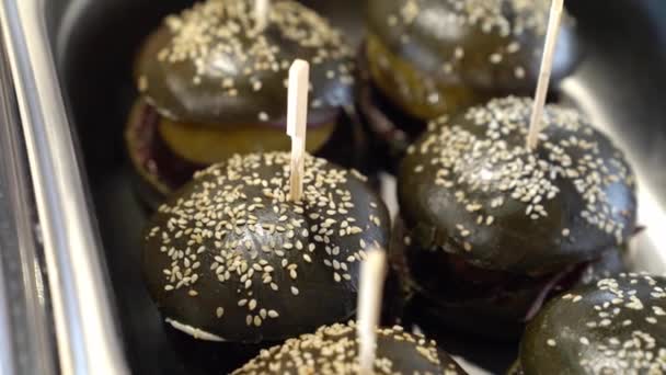 Hamburgers noirs sur un plateau en métal. buffet pour les vacances — Video
