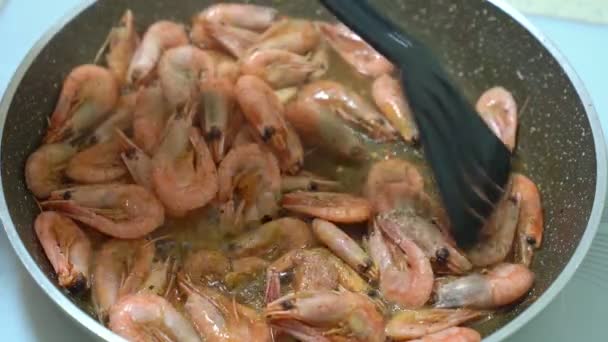 Camarones fritos en sartén y mezclar negro con una espátula . — Vídeos de Stock