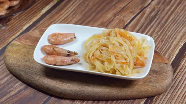 Na bílém talíři s nudlemi Udon dát tyčinky krevety — Stock video