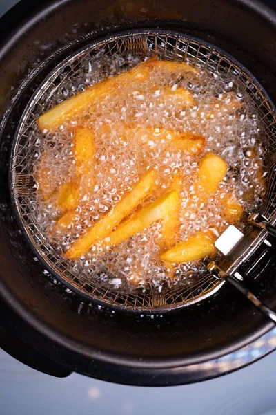 Papas fritas. aceite hirviendo en una freidora en casa . — Foto de Stock