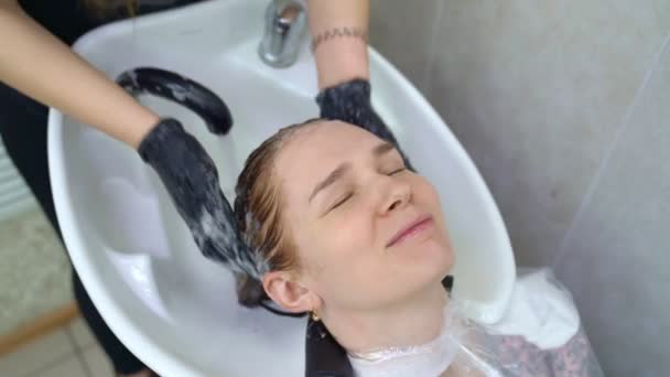 Шампунь після фарбування волосся. руки в рукавичках . — стокове відео