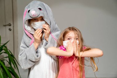 Çocuklar karantina salgınında pijama ve maskeli.