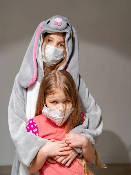 Niños en pijama y máscaras en cuarentena abrazo — Foto de Stock