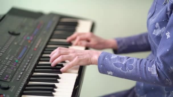 Handen oudere vrouw naar de synth melodie te spelen. — Stockvideo