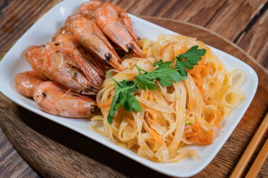 Udon eriştesi ve kızarmış karides tabağında..