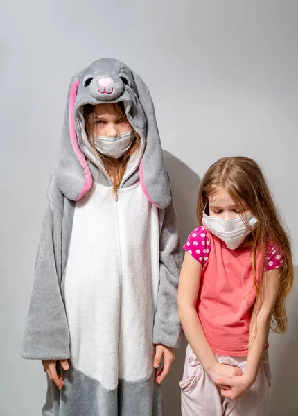 Niños tristes en pijama, máscaras en la epidemia de cuarentena — Foto de Stock
