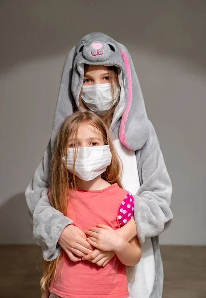 Niños tristes en pijama, máscaras en cuarentena abrazo — Foto de Stock