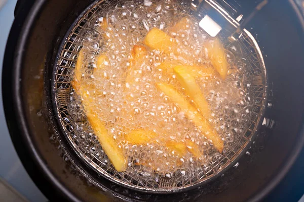 Pommes frites. olja som kokar i en fritös hemma. — Stockfoto