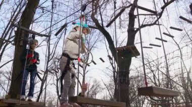 little girl is afraid to climb the rope Park.