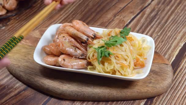 White plate with Udon noodles, shrimp put sticks. — Stock Video