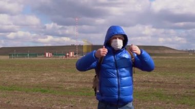 Mavi ceketli, tıbbi maskeli adam başlığı çıkarıyor.