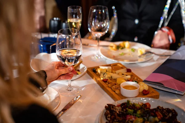 Mãos de pessoas com copos de vinho na mesa de férias — Fotografia de Stock