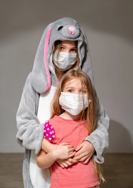 Niños tristes en pijama, máscaras en cuarentena abrazo — Foto de Stock