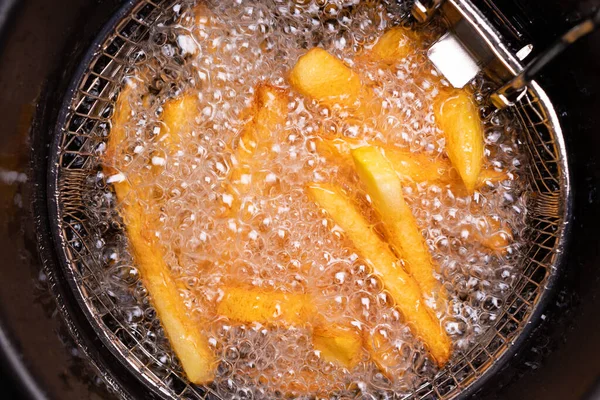 Batatas fritas. fervura de óleo em uma fritadeira em casa . — Fotografia de Stock