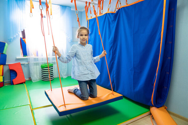 маленькая девочка на платформе сенсорной интеграции
 