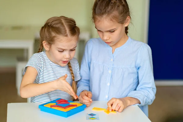 Duas garotinha argumentam resolver quebra-cabeça matemático . — Fotografia de Stock