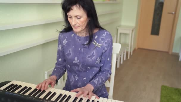 Oudere vrouw om de synth melodie te spelen. — Stockvideo