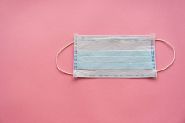 Pembe arka planda tek kullanımlık tıbbi maske.