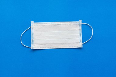 Mavi arka planda tek kullanımlık tıbbi maske..