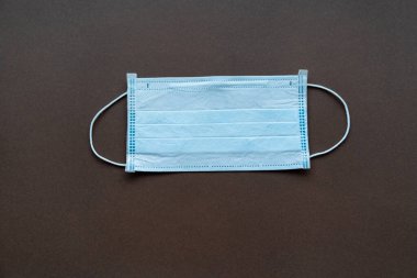 Siyah arka planda tek kullanımlık mavi tıbbi maske.