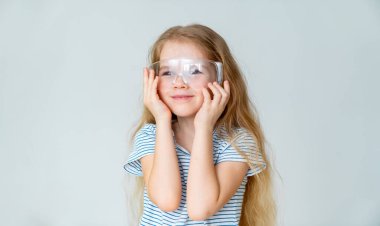 Gülümseyen küçük kız koruyucu gözlük takıyor..