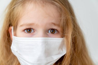 Beyaz arka planda tıbbi maskeli kız. Yaklaş. 