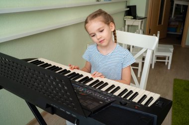 Küçük bir kız sentezleyici çalmayı öğreniyor.. 