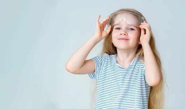 Petite fille enlève les lunettes de sécurité . — Photo