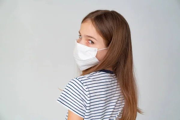 Adolescente chica en médico máscara en blanco fondo —  Fotos de Stock