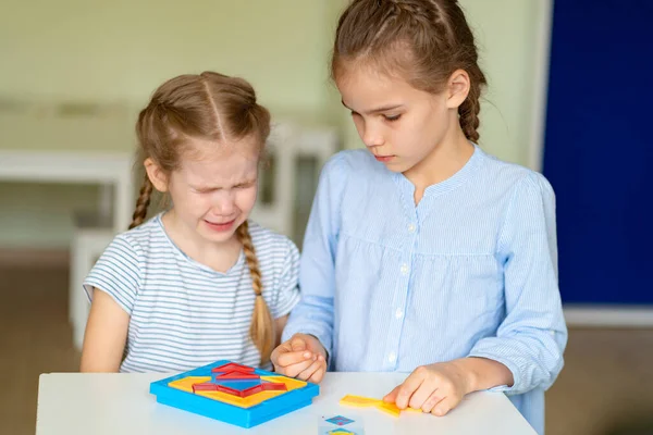 Dwie dziewczynki zdenerwowany rozwiązać zagadkę matematyczną. — Zdjęcie stockowe
