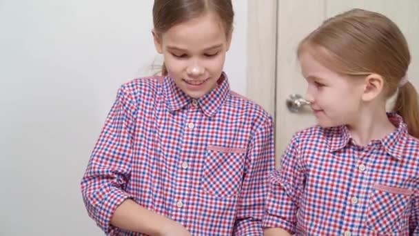 Twee zussen koken samen en spelen met bloem. — Stockvideo