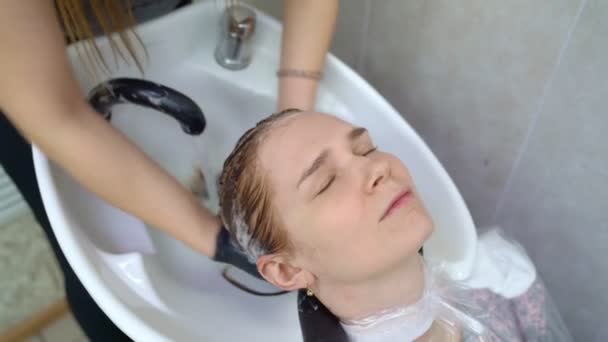 Shampoo na haarkleuring. handen in handschoenen. — Stockvideo