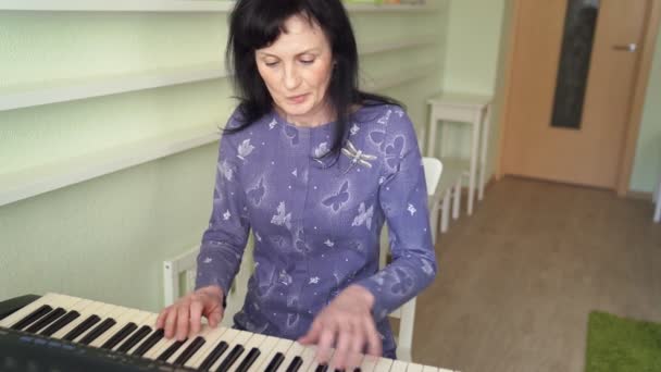 Oudere vrouw om de synth melodie te spelen. — Stockvideo