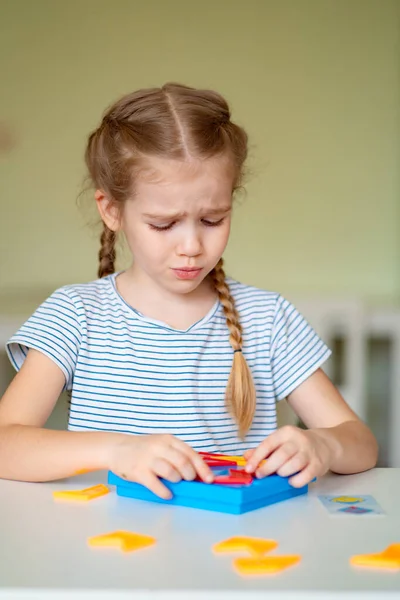 Zdenerwowana dziewczynka rozwiązać zagadkę matematyczną. — Zdjęcie stockowe