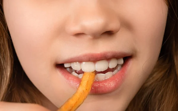 Uma boca adolescente comendo batatas fritas close-up . — Fotografia de Stock