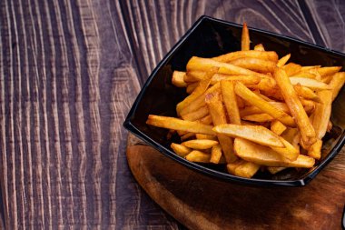 Patates kızartması, tahtadan yapılmış siyah tabakta..