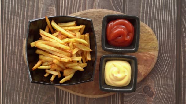 Hand neemt en dompelt frietjes in saus en ketchup — Stockvideo