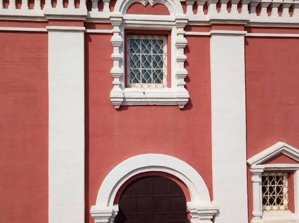 Rode muur met ramen en deur. witte elementen. — Stockfoto