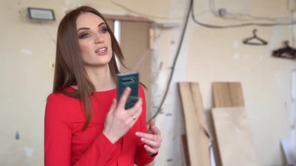 Mädchen in rotem Kleid telefoniert auf Baustelle — Stockvideo