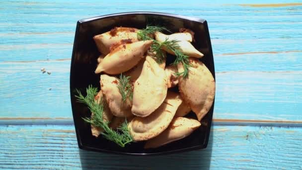 Глибокі смажені картопляні пельмені в тарілці з зеленню — стокове відео