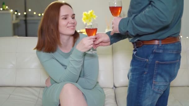 Мужчина принес бокал вина женщина сидит на диване . — стоковое видео