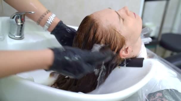 Мытье после окрашивания волос. руки в перчатках . — стоковое видео