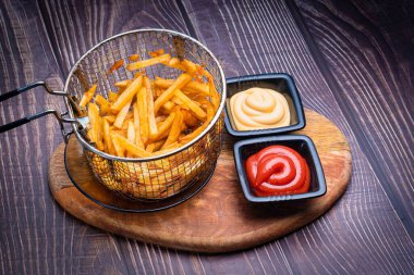 Kızartma sepetinde patates kızartması, iki sos..