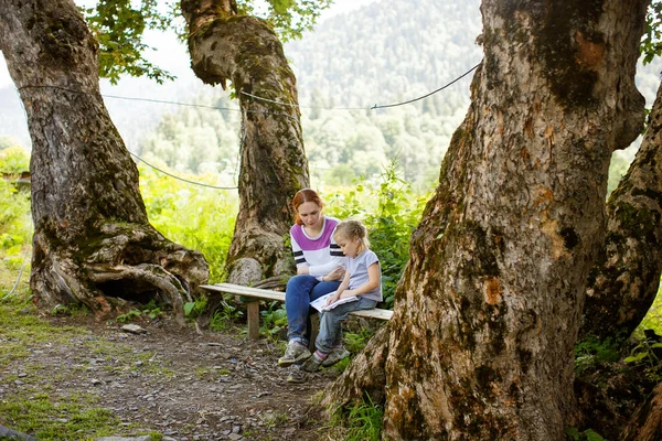 Mamãe ensina filha lida em montanhas de acampamento — Fotografia de Stock