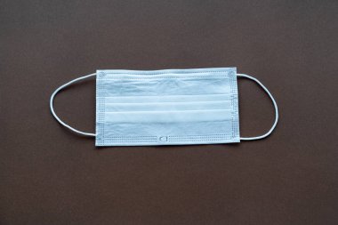 Siyah arka planda tek kullanımlık mavi tıbbi maske.