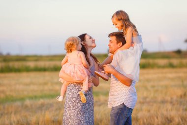 Aile kırsalda gün batımında oynuyor. 