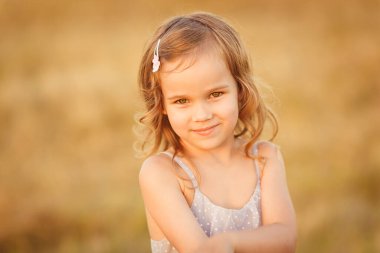 Gri elbiseli kız eğimli buğday tarlasında duruyor