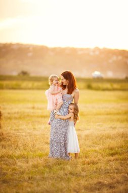 Anne ve iki kızı dikildi ve biçilmiş tarlaya sarıldı.