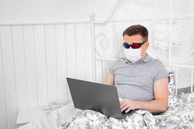 Tıbbi maskeli erkek ve 3D gözlükler film izliyor.