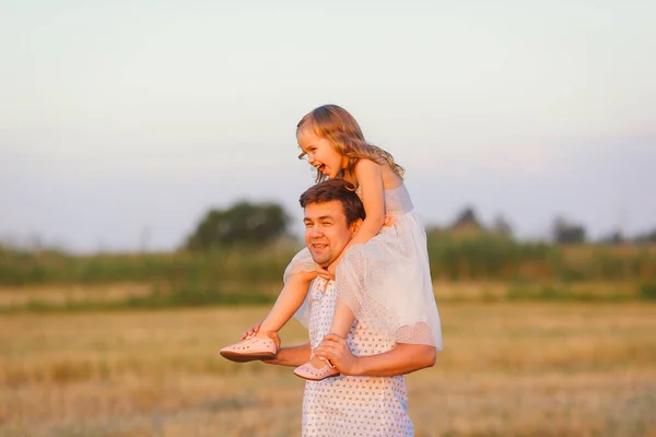 Pai passeio filha em ombros no campo de restolho — Fotografia de Stock
